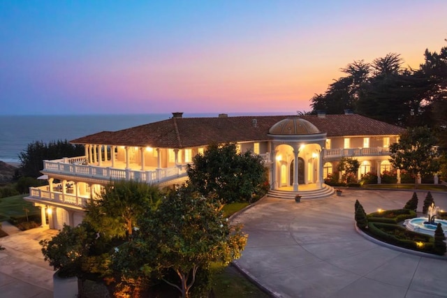 view of front of property featuring a balcony and a water view