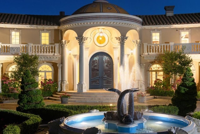 exterior space featuring a balcony, sink, and french doors