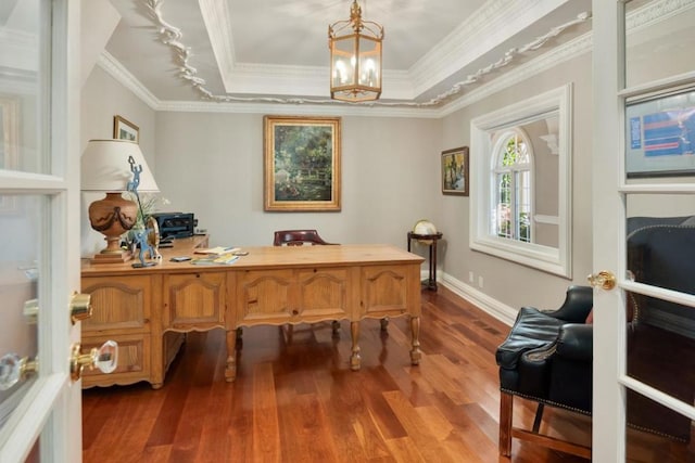 office with hardwood / wood-style flooring, a notable chandelier, a raised ceiling, and crown molding