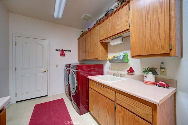 clothes washing area with cabinets, sink, and washer and dryer