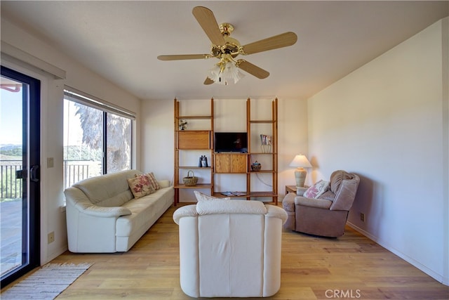 living room featuring light hardwood / wood-style floors and ceiling fan