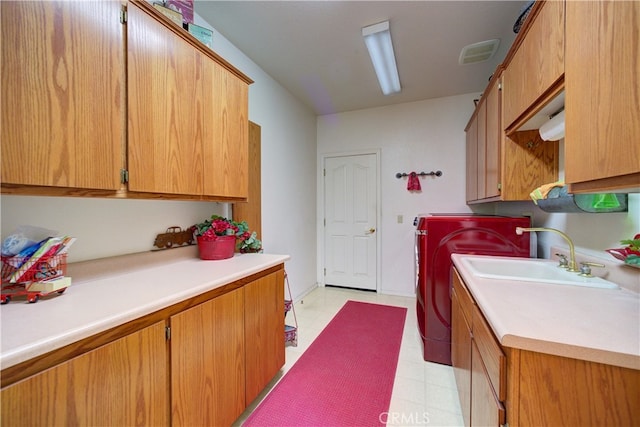 clothes washing area featuring cabinets, sink, and independent washer and dryer