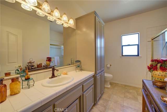 bathroom featuring vanity, tile patterned flooring, toilet, and an enclosed shower