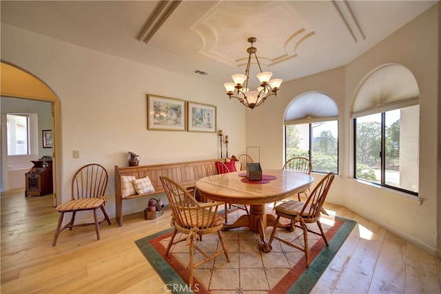 dining space featuring an inviting chandelier and light hardwood / wood-style flooring