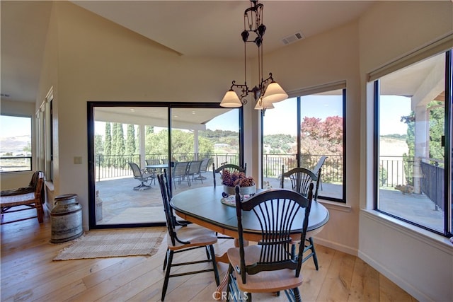 dining space featuring light wood-type flooring and a notable chandelier