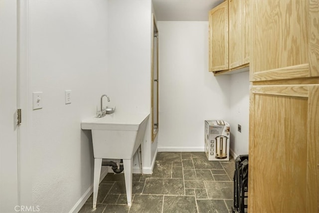 laundry room with dark tile patterned flooring and cabinets