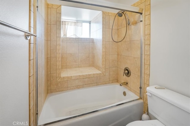 bathroom with bath / shower combo with glass door and toilet