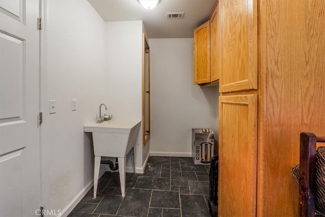 laundry area featuring dark tile patterned floors