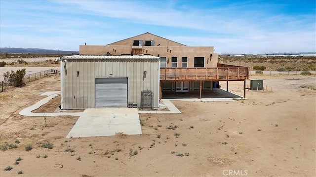 view of front facade with a deck, a garage, and an outdoor structure