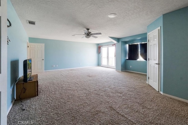 unfurnished living room with ceiling fan, a textured ceiling, and carpet floors