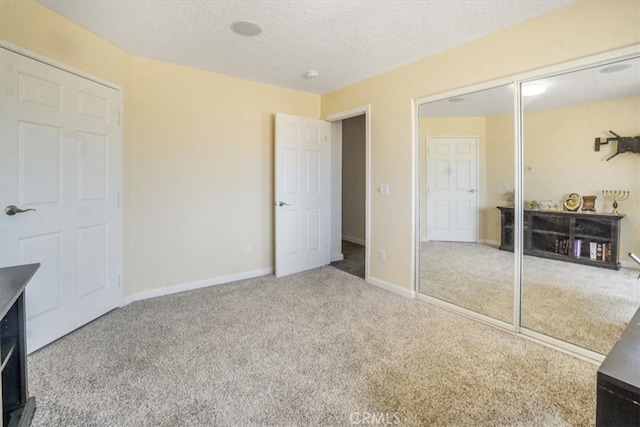 bedroom featuring a textured ceiling, light carpet, and a closet