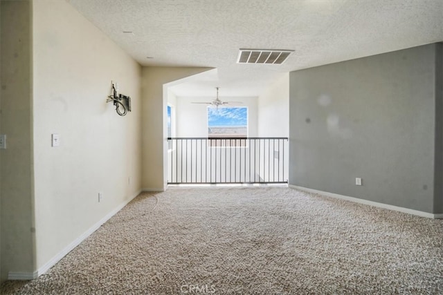 empty room with a textured ceiling, ceiling fan, and carpet floors