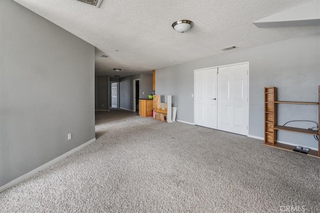 spare room featuring carpet flooring and a textured ceiling