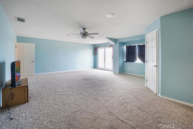 unfurnished living room featuring ceiling fan, carpet flooring, and a textured ceiling