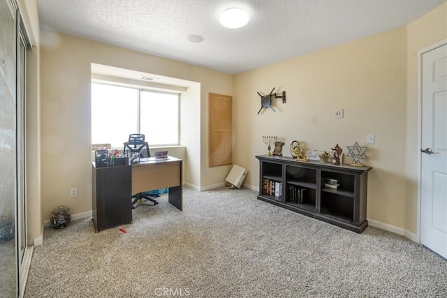 carpeted home office with a textured ceiling