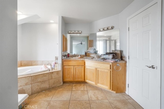 bathroom with tile patterned floors, vanity, and tiled tub