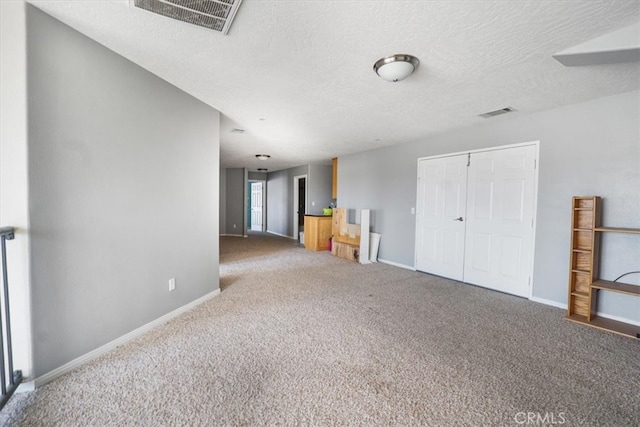 unfurnished bedroom with a textured ceiling, a closet, and carpet floors