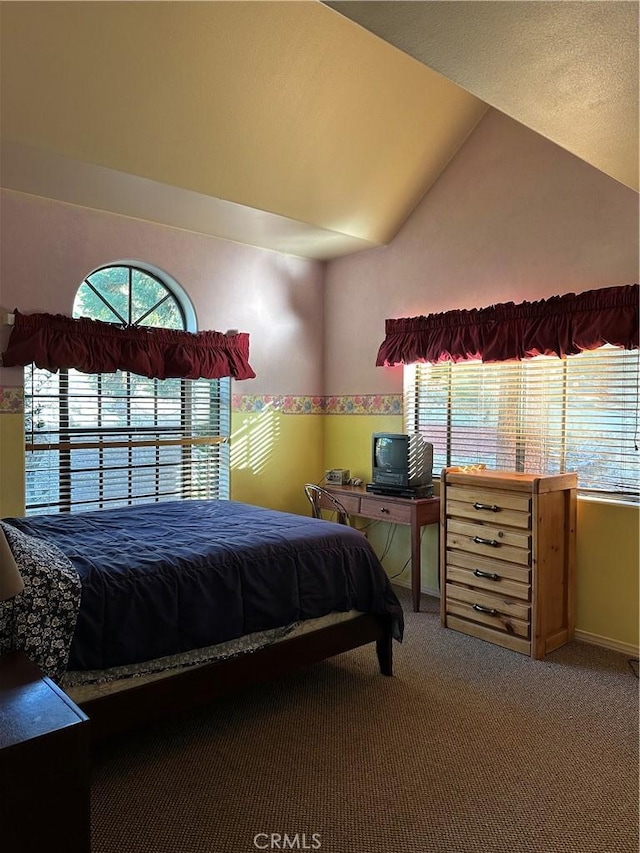 carpeted bedroom featuring lofted ceiling and baseboards