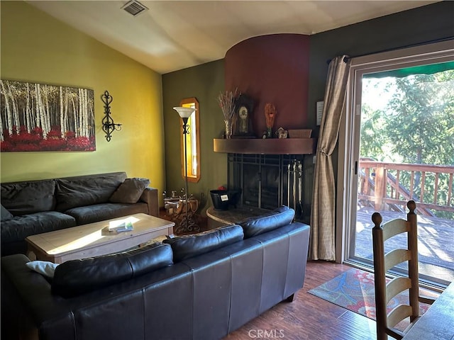 living room featuring a fireplace, dark wood-type flooring, and lofted ceiling