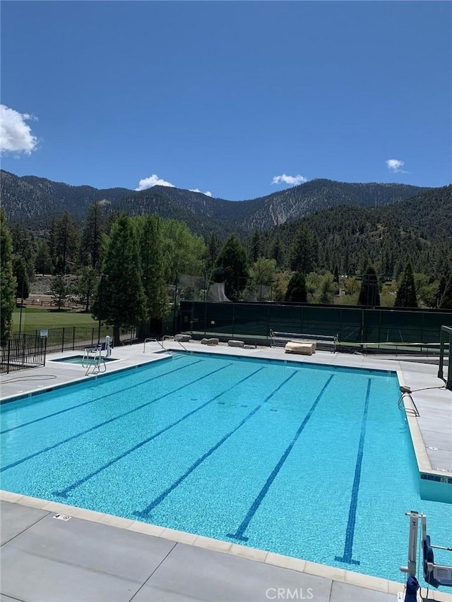 view of swimming pool with a mountain view and a patio