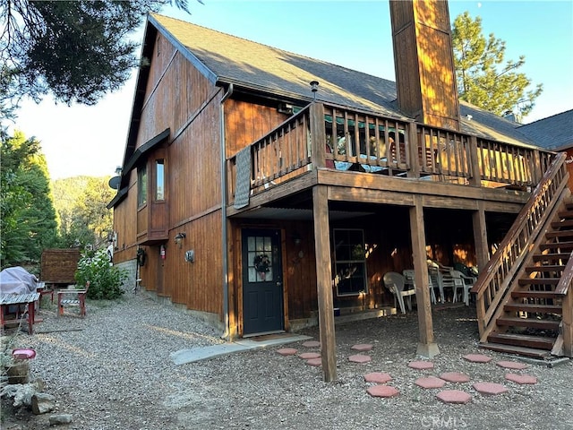 back of property featuring stairway and a deck
