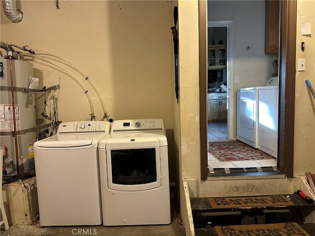 clothes washing area featuring secured water heater and washing machine and clothes dryer