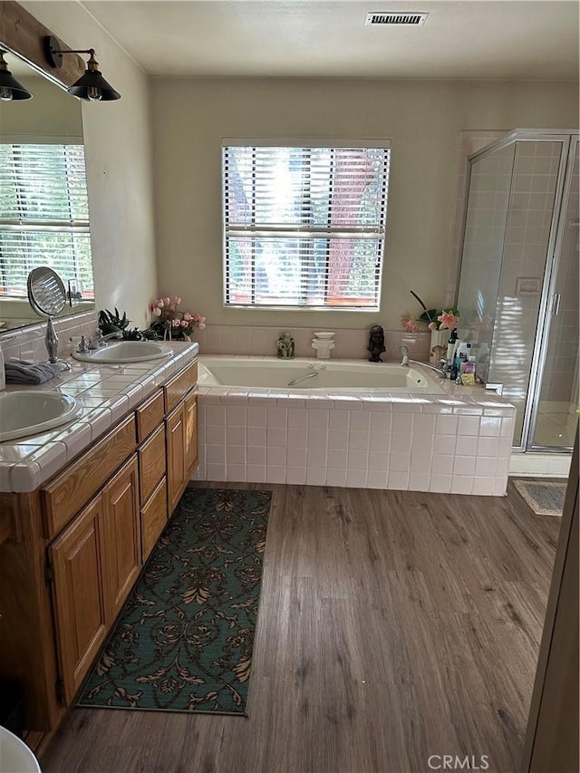 bathroom featuring hardwood / wood-style floors, plenty of natural light, independent shower and bath, and vanity