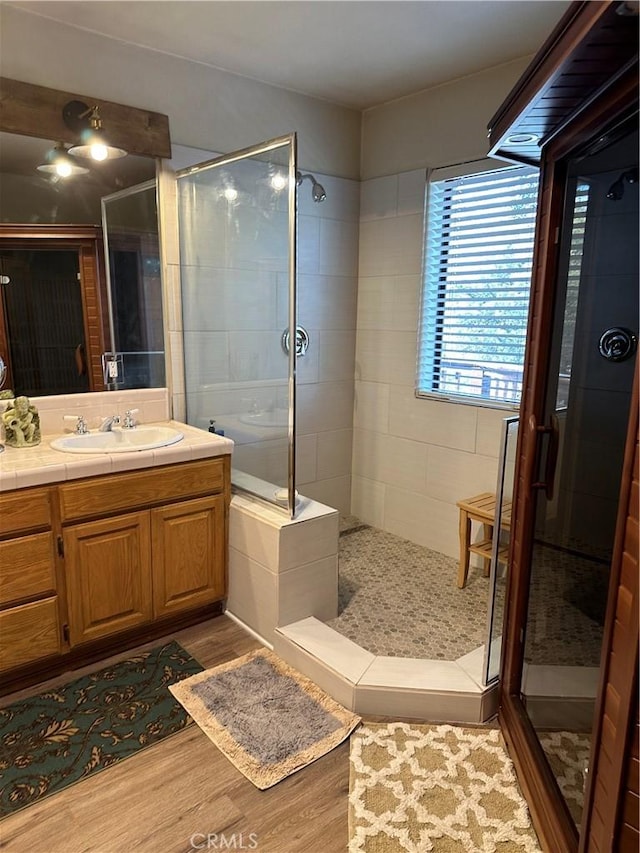 bathroom with a shower stall, vanity, and wood finished floors