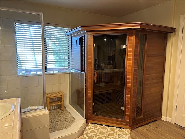 bathroom featuring wood finished floors, a sauna, and a stall shower