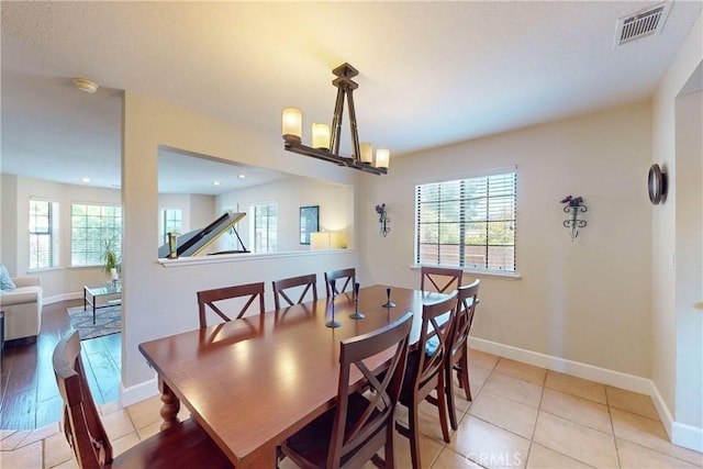 tiled dining area featuring a notable chandelier