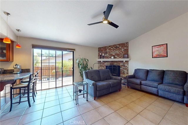 tiled living room with ceiling fan, lofted ceiling, and a fireplace