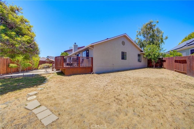 rear view of property with a yard, a patio, and a wooden deck