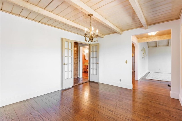 unfurnished room featuring dark hardwood / wood-style flooring, beam ceiling, wooden ceiling, an inviting chandelier, and french doors