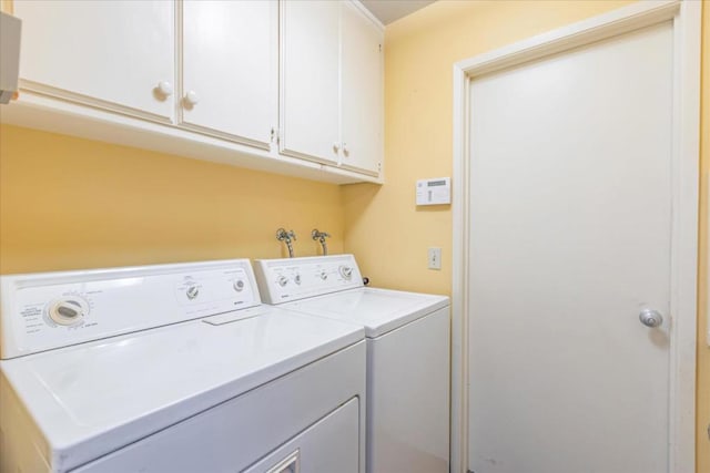 washroom with washer and clothes dryer and cabinets