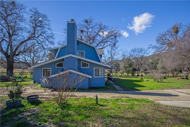 rear view of property with a lawn and a mountain view