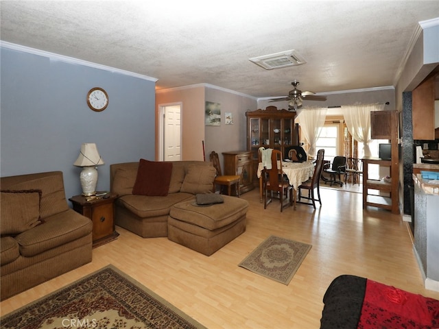 living room featuring crown molding, ceiling fan, and light hardwood / wood-style floors