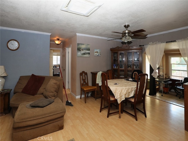 dining area featuring light wood-type flooring, crown molding, a wealth of natural light, and ceiling fan