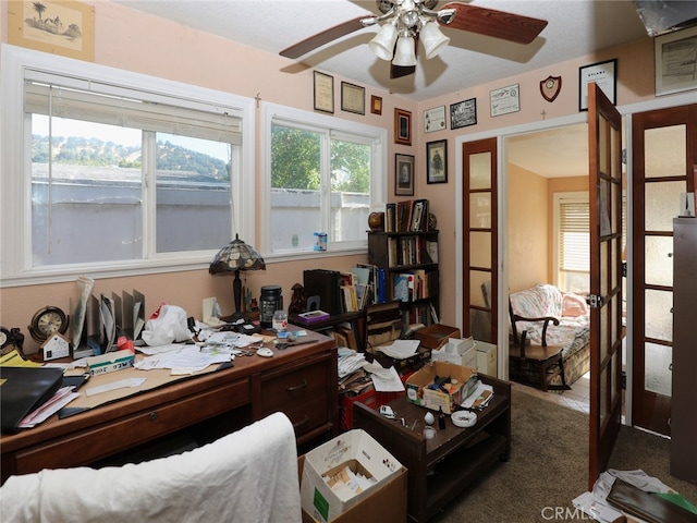 carpeted office space with ceiling fan