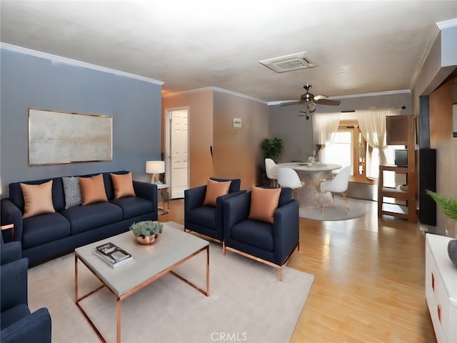 living room featuring light wood-type flooring, ornamental molding, and ceiling fan