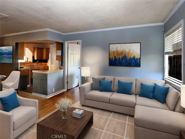 living room with ornamental molding, a textured ceiling, sink, and light hardwood / wood-style floors