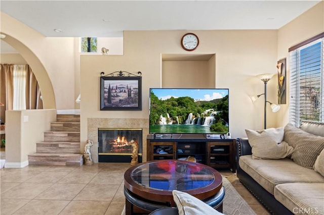 tiled living area with stairway and a tiled fireplace