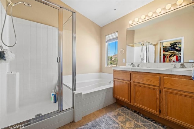 full bathroom featuring a bath, a shower stall, double vanity, and a sink