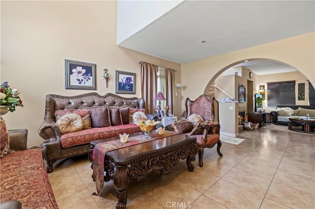 living area featuring light tile patterned flooring and arched walkways