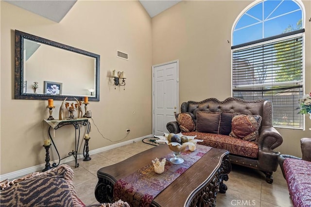 living room with tile patterned floors, a high ceiling, and baseboards