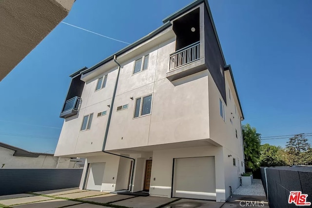 2151 S W View St, Los Angeles, CA 90016 - back of property with a balcony, stucco siding, and a garage