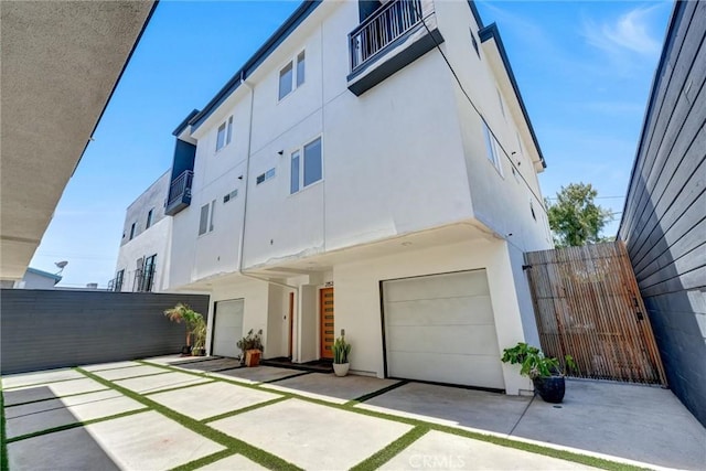 2151 S W View St, Los Angeles, CA 90016 - back of house featuring stucco siding, an attached garage, a gate, and a balcony