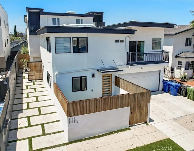 2151 S W View St, Los Angeles, CA 90016 - view of front facade featuring stucco siding, concrete driveway, a garage, and a balcony