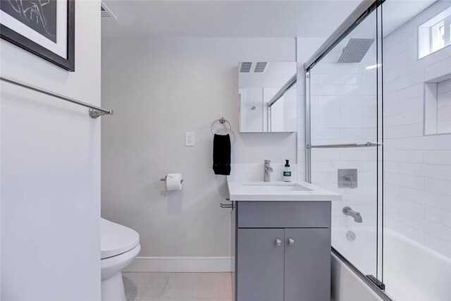 full bathroom featuring toilet, bath / shower combo with glass door, vanity, and tile patterned floors