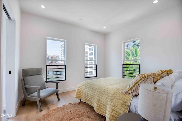 bedroom featuring a closet, multiple windows, and light hardwood / wood-style floors