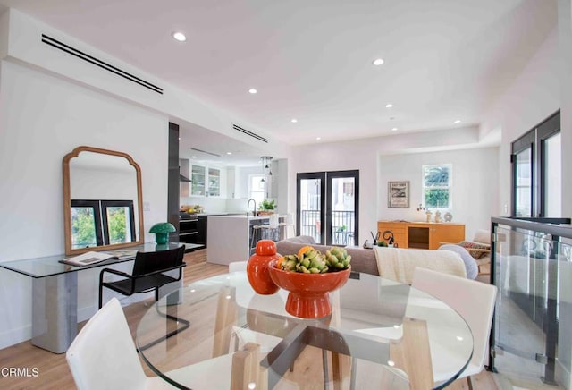 dining area with french doors, sink, and light hardwood / wood-style floors